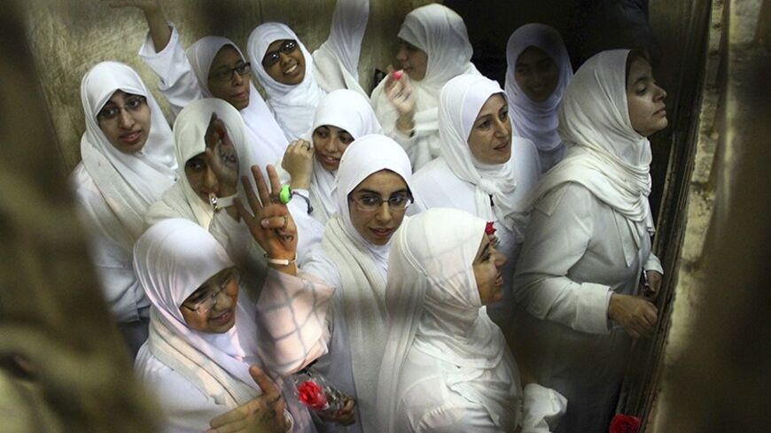 Women, who were found guilty of obstructing traffic during a pro-Islamist protest in October, gesture during their appeal hearing at a court in the Mediterranean city of Alexandria, 230 km (143 miles) north of Cairo December 7, 2013. Last month, 14 women were imprisoned for 11 years, while seven teenage girls under the age of 18 were sent to juvenile prison.  REUTERS/Stringer (EGYPT - Tags: POLITICS CRIME LAW CIVIL UNREST) - RTX1685G