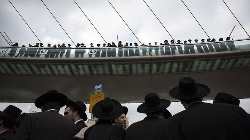 Ultra-Orthodox Jewish protesters, some standing on a bridge, take part a demonstration in Jerusalem February 6, 2014. Hundreds of ultra-Orthodox Jews in Israel blocked highways and clashed with police on Thursday in protest at a government decision to cut funds to seminary students who avoid military service. REUTERS/Baz Ratner (JERUSALEM - Tags: POLITICS RELIGION CIVIL UNREST) - RTX18AZA