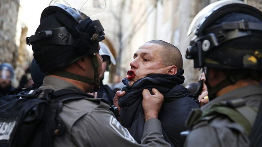 An Israeli policeman scuffles with a Palestinian during clashes near Lion's Gate in Jerusalem's Old City February 7, 2014. Tensions briefly ran high on Friday in Jerusalem's Old City following clashes that erupted between Israeli police and stone-throwing Palestinians on a compound known to Muslims as Noble Sanctuary and to Jews as Temple Mount. REUTERS/Darren Whiteside (JERUSALEM - Tags: RELIGION POLITICS CIVIL UNREST TPX IMAGES OF THE DAY) - RTX18CFC