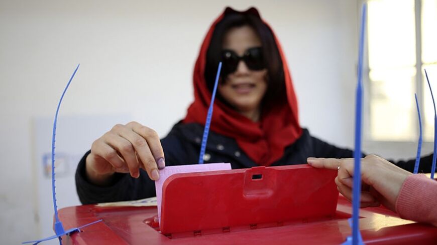 A woman casts her ballot during a vote to elect a constitution-drafting panel in Benghazi February 20, 2014. Libyans head to the polls on Thursday to elect a body to draft a new constitution, marking a step in the country's transition after the overthrow of dictator Muammar Gaddafi in 2011. REUTERS/Esam Omran Al-Fetori (LIBYA - Tags: POLITICS ELECTIONS) - RTX195QQ
