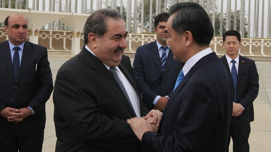 Iraq's Foreign Minister Hoshyar Zebari (L) welcomes Chinese Foreign Minister Wang Yi (R) at his arrival to Baghdad's airport February 23, 2014. REUTERS/Ahmed Saad (IRAQ - Tags: POLITICS) - RTX19COB