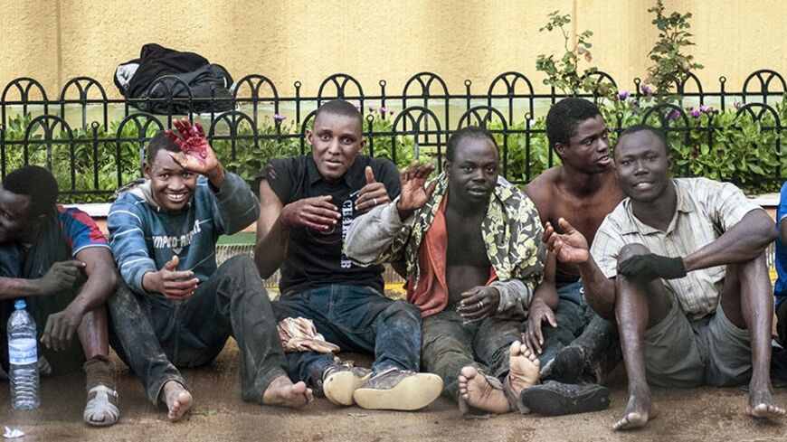Immigrants sit with bare feet and bloodied hands after scaling a border fence to enter the Spanish enclave Melilla from neighboring Morocco, February 24, 2014. Over one hundred immigrants successfully entered Melilla according to a statement Spain's Interior Ministry.  Spain has two enclaves in the north African country, Ceuta and Mellila, and migrants regularly try to reach them either by swimming along the coast or climbing the triple fences that separate them from Morocco.  REUTERS/Jesus Blasco de Avella