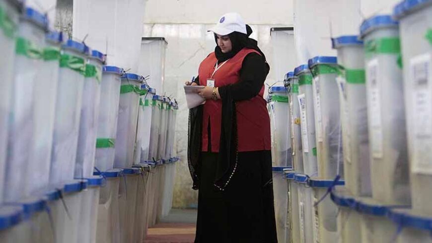 A worker from the Independent High Electoral Commission (IHEC) checks boxes containing ballots during vote counting at an analysis centre in Basra, 420 km (261 miles) southeast of Baghdad April 21, 2013. Voter participation in Iraq's provincial election on Saturday was 50 percent of eligible voters, the country's electoral authorities said after poll stations closed. REUTERS/Atef Hassan (IRAQ - Tags: POLITICS ELECTIONS TPX IMAGES OF THE DAY) - RTXYUKT