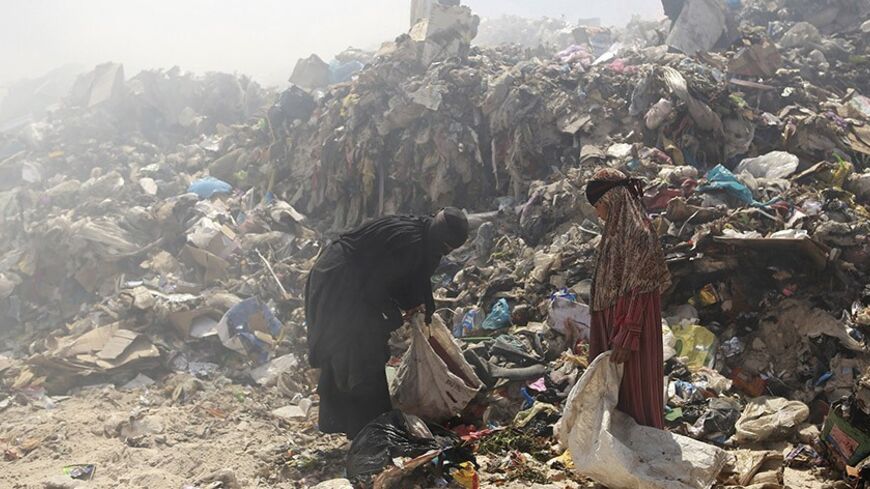 People collect garbage to be sorted and sold to nearby recycling centres in a district near Najaf, 160 km (99 miles) south of Baghdad April 30, 2013. REUTERS/Ahmed Mousa (IRAQ - Tags: SOCIETY POVERTY) - RTXZ4UN