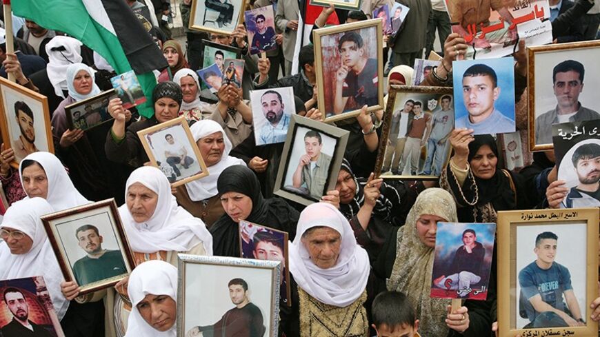 Palestinian women hold pictures of jailed relatives during a protest marking "Palestinian Prisoners Day" in the West Bank town of Ramallah April 17, 2007. The women were calling for the release of Palestinian prisoners in Israeli jails. Palestinian Prime Minister Ismail Haniyeh said on Monday that Marwan Barghouthi, a Palestinian uprising leader, is on a list of prisoners the Hamas movement demands Israel release in exchange for a captive soldier. REUTERS/Oleg Popov   (WEST BANK) - RTR1OPVW