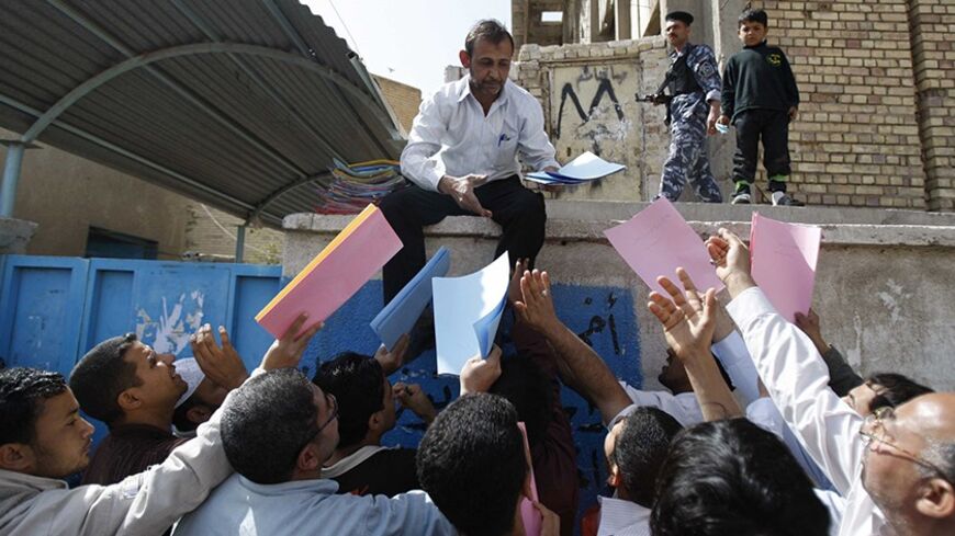 An employee from an employment centre receives files from residents seeking jobs in Basra, 420 km (260 miles) southeast of Baghdad March 1, 2011. Hundreds of residents gathered on Tuesday in front of an employment centre to submit files of their documents and CV's following recent demonstrations demanding improved basic services and job opportunities in Iraq's southern oil hub of Basra.  REUTERS/Atef Hassan (IRAQ - Tags: POLITICS EMPLOYMENT BUSINESS) - RTR2JAA6