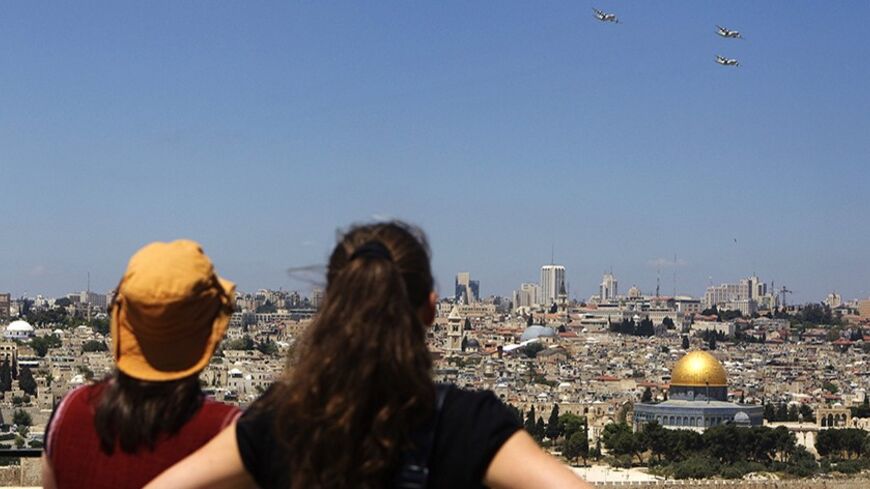 People watch planes from the Israeli Air Force fly over Jerusalem during celebrations marking Israel's 63rd Independence Day in Jerusalem May 10, 2011.  REUTERS/Darren Whiteside  (JERUSALEM - Tags: ANNIVERSARY MILITARY TRANSPORT) - RTR2M7SX