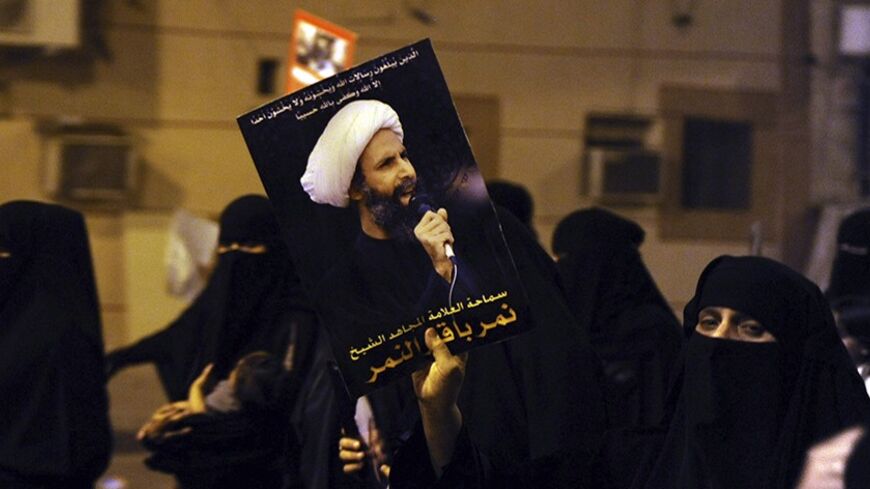 A protester holds up a picture of Sheikh Nimr al-Nimr during a rally at the coastal town of Qatif, against Sheikh Nimr's arrest July 8, 2012. Sheikh Nimr, a prominent Shi'ite Muslim cleric who was wanted by the police, was detained in Saudi Arabia's Eastern Province on Sunday over calls for more rights for the minority Muslim sect in the Sunni monarchy, his brother and an activist said. REUTERS/Stringer (SAUDI ARABIA - Tags: CIVIL UNREST RELIGION POLITICS) - RTR34QU8
