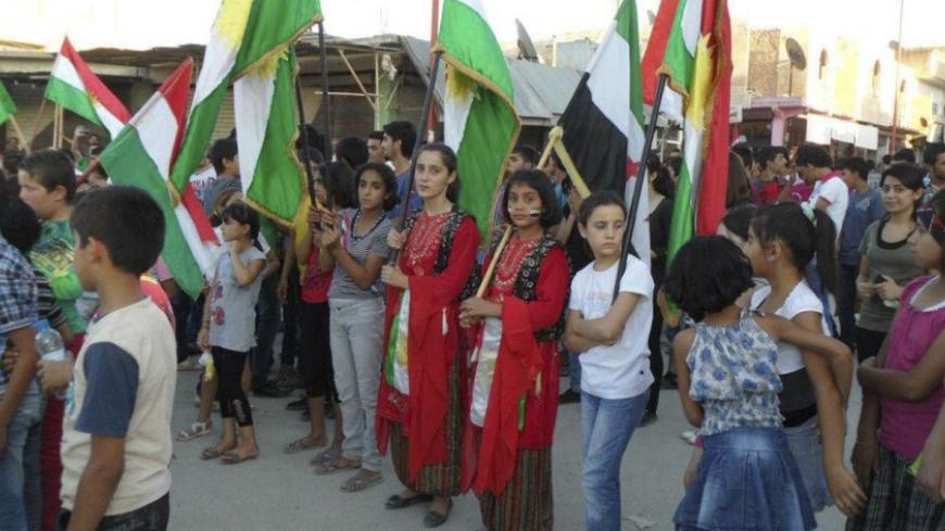 Demonstrators hold Kurdish and Syrian opposition flags during a protest against Syria's President Bashar al-Assad in Kobani, near Aleppo, July 16, 2012. Picture taken July 16, 2012. REUTERS/Shaam News Network/Handout (SYRIA - Tags: POLITICS CIVIL UNREST CONFLICT) FOR EDITORIAL USE ONLY. NOT FOR SALE FOR MARKETING OR ADVERTISING CAMPAIGNS. THIS IMAGE HAS BEEN SUPPLIED BY A THIRD PARTY. IT IS DISTRIBUTED, EXACTLY AS RECEIVED BY REUTERS, AS A SERVICE TO CLIENTS - RTR350D5