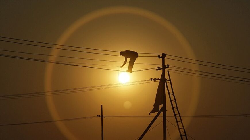 An employee from the electricity board works on newly installed overhead power cables ahead of the "Kumbh Mela", or Pitcher Festival, as the sun sets in the northern Indian city of Allahabad December 7, 2012. REUTERS/Jitendra Prakash (INDIA - Tags: ENERGY BUSINESS EMPLOYMENT TPX IMAGES OF THE DAY) - RTR3BBCN
