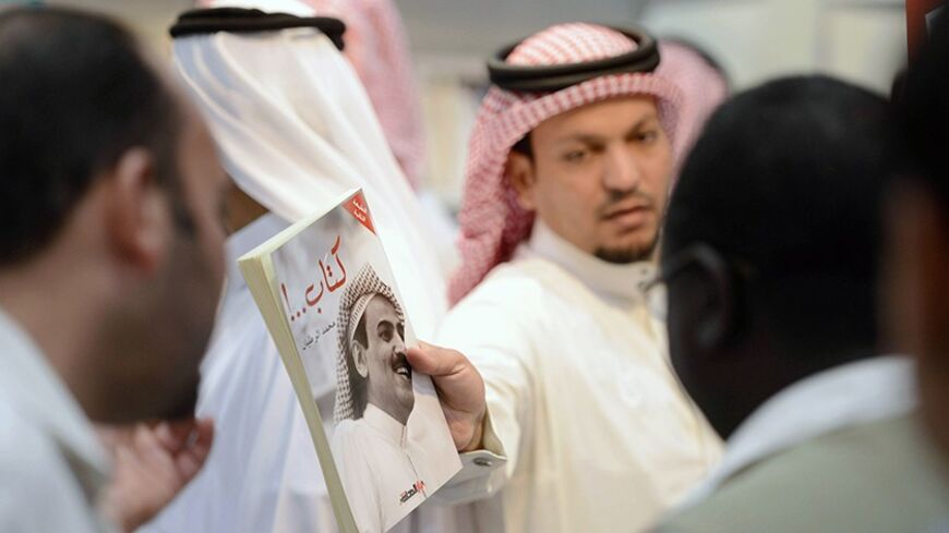 A man shows a book by Saudi writer and poet Mohamed Al-Rotayyan during the Riyadh Book Fair at the International Exhibition Center in Riyadh March 9, 2013. Picture taken March 9, 2013. REUTERS/Faisal Al Nassar (SAUDI ARABIA - Tags: EDUCATION SOCIETY) - RTR3ET2Q