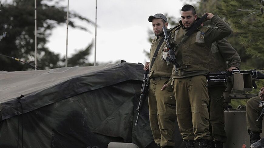 Israeli soldiers stand atop an armoured personnel carrier (APC) positioned near the Lebanese border, close to the northern Israeli town of Shlomi February 27, 2014. Israel's northern region near Lebanon was tense on Thursday and the military ordered farmers away from fields abutting the border, a day after the Lebanese Hezbollah militia threatened to respond to an Israeli air strike that hit one of its bases on the border with Syria earlier in the week. REUTERS/Ammar Awad (ISRAEL - Tags: MILITARY POLITICS) 