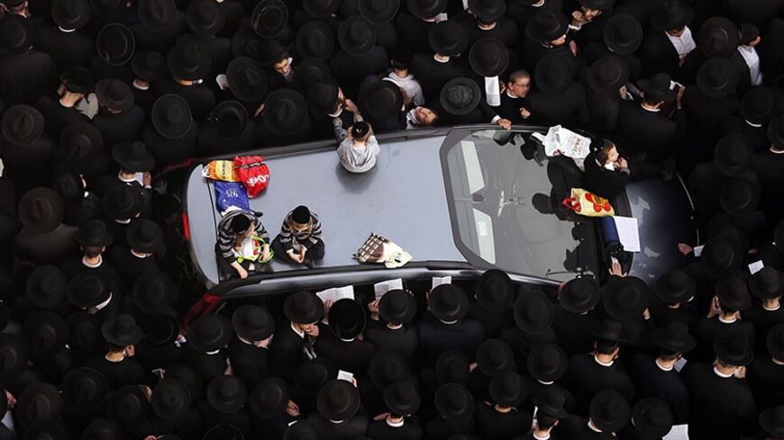 Ultra-Orthodox Jewish men stand around a car during a mass prayer in Jerusalem March 2, 2014. Hundreds of thousands of ultra-Orthodox Jews held a mass prayer in Jerusalem on Sunday in protest at a bill that would cut their community's military exemptions and end a tradition upheld since Israel's foundation.   REUTERS/Darren Whiteside (JERUSALEM - Tags: POLITICS RELIGION MILITARY TPX IMAGES OF THE DAY) - RTR3FWQW