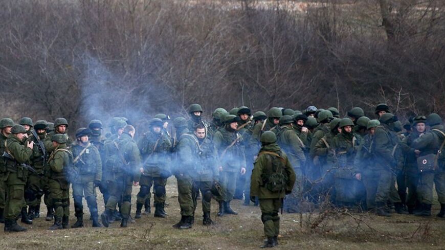 Armed men, believed to be Russian soldiers, assemble near an Ukrainian military base in Perevalnoe March 5, 2014. Ukraine's government said on Wednesday "Russian aggression" in Crimea was hitting the country's economy hard but signalled growing confidence that it will secure international loans and avoid bankruptcy. REUTERS/Thomas Peter (UKRAINE - Tags: POLITICS MILITARY) - RTR3G2SD