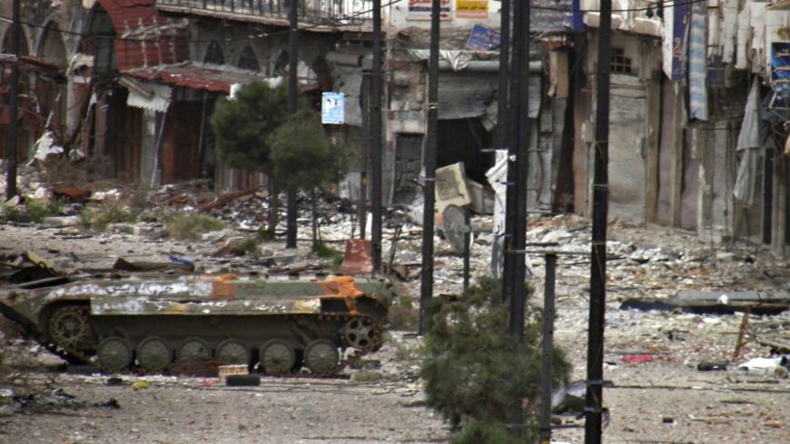 A damaged armoured carrier that belonged to forces loyal to president Bashar al-Assad are seen along a deserted street in Homs March 8, 2014  REUTERS/Thaer Al Khalidiya (SYRIA - Tags: POLITICS CIVIL UNREST CONFLICT) - RTR3G99W
