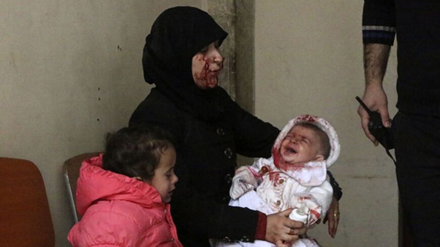 A woman survivor holds her crying baby in a hospital in Aleppo's al-Sakhour district, after what activists said was a barrel bomb dropped at Aleppo's Haydariye district by forces loyal to Syria's President Bashar al-Assad, March 9, 2014. REUTERS/Hosam Katan (SYRIA - Tags: CIVIL UNREST POLITICS CONFLICT TPX IMAGES OF THE DAY) - RTR3GBX1