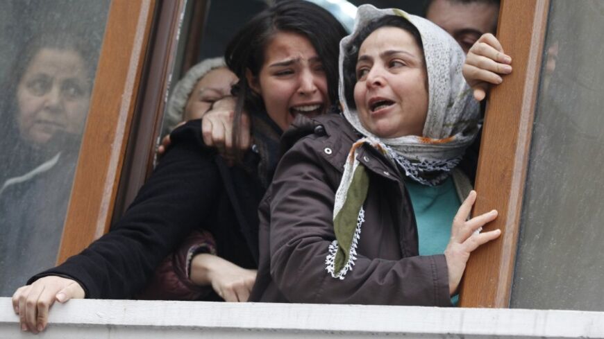 Berkin Elvan's sister Ozge (C) reacts as his coffin approaches the Okmeydani cemevi, an Alevi place of worship, in Istanbul March 11, 2014. Police and protesters clashed in Turkey's two biggest cities on Tuesday following the death of the 15-year-old boy who suffered a head injury during anti-government demonstrations last summer. Elvan, then aged 14, got caught up in street battles in Istanbul between police and protesters on June 16 after going out to buy bread for his family. He was struck in the head by
