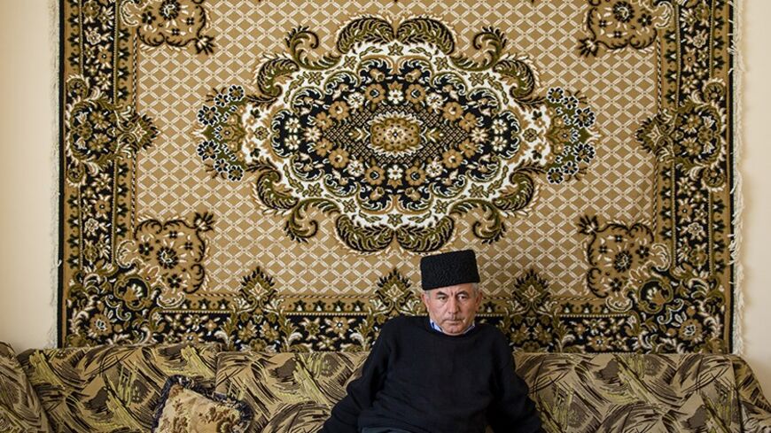 Mustafa Asaba, a regional leader of Crimean Tatars, sits in the living room of a friend's home in Belogorsk near the Crimean capital of Simferopol March 17, 2014. Among the voices drowned out by victory celebrations across Crimea as it voted to leave Ukraine and join Russia were those of the Tatars, a minority group for whom the prospect of a return to Moscow rule brings fear and uncertainty. Picture taken March 17, 2014.  REUTERS/Thomas Peter (UKRAINE  - Tags: POLITICS SOCIETY) - RTR3HIWN