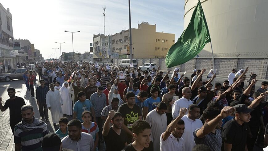 Mourners and family of Jawad Al-Haawi shout anti-government slogans as they march during his funeral process in the village of Sitra south of Manama, March 18, 2014. 
Authorities said that Al Haawi died from heart attack and investigation is still under process. Opposition says that he died from inhalation of tear-gas fired by riot-police in the village. Al Haawi died on Sunday. REUTERS/Stringer (BAHRAIN - Tags: POLITICS CIVIL UNREST) - RTR3HN4R