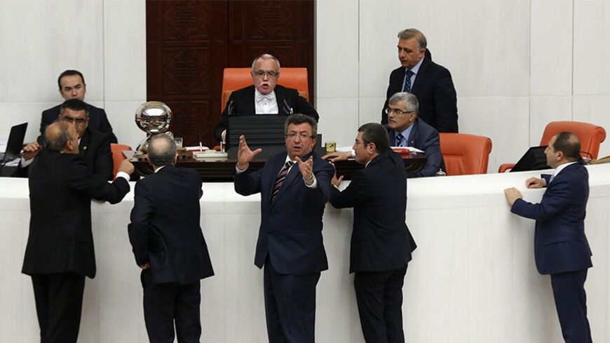 Opposition members of the Turkish Parliament protest Deputy Chairman of the Parliament Sadik Yakut (rear, C) during a debate in Ankara March 19, 2014. Parliament convened in the capital Ankara for the hearing of a prosecutor report allegedly outlining the role of four former ministers in a corruption scandal that became public in December 2013. REUTERS/Umit Bektas (TURKEY - Tags: POLITICS) - RTR3HR3K