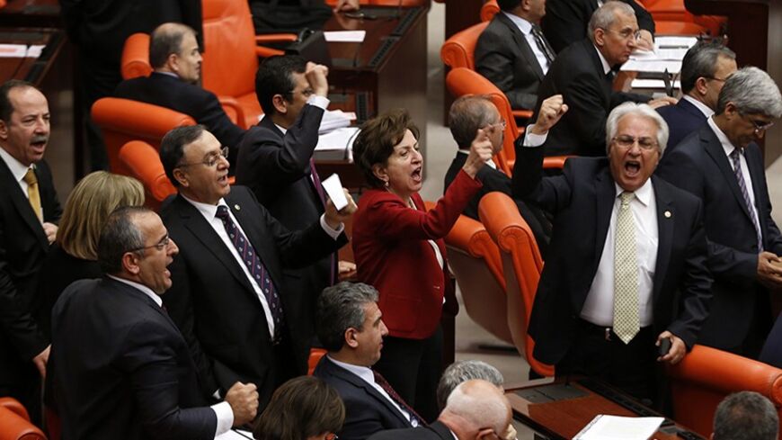 MPs of Turkey's main opposition Republican People's Party (CHP) shout slogans against the ruling AK Party (AKP) during a debate in Ankara March 19, 2014. Parliament convened in the capital Ankara for the hearing of a prosecutor report allegedly outlining the role of four former ministers in a corruption scandal that became public in December 2013. REUTERS/Umit Bektas (TURKEY - Tags: POLITICS) - RTR3HS83