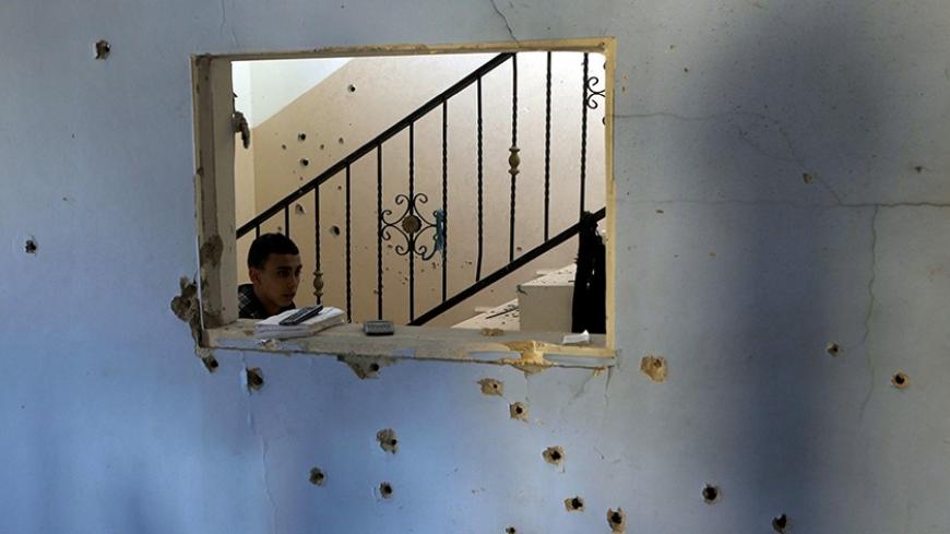 A boy walks past a bullet-riddled wall inside a house where Palestinian Hamas militant Hamza Abu Alhija was killed in the West Bank refugee camp of Jenin March 22, 2014. Israeli forces shot and killed four Palestinians on Saturday during a raid on the home in the occupied West Bank to capture Alhija, a wanted Hamas Islamist militant, the Israeli military said. Hamas supporters carried three bodies through the streets of the West Bank city of Jenin, shouting slogans against Palestinian President Mahmoud Abba