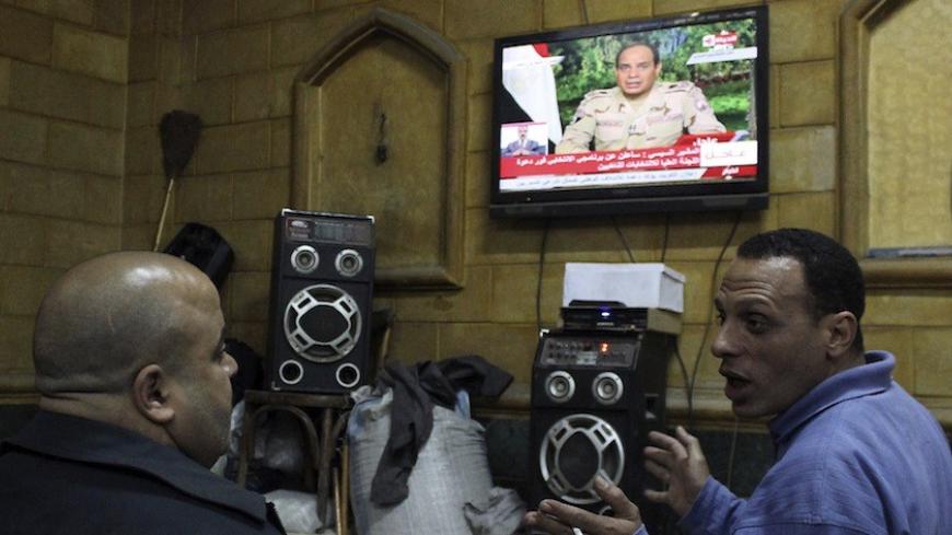 People listen to the speech by Egypt's army chief Field Marshal Abdel Fattah al-Sisi declaring his candidacy for a presidential election, in a public cafe in Cairo March 26, 2014. Al-Sisi, the general who ousted Egypt's first freely elected leader, on Wednesday declared his candidacy for a presidential election he is expected to win easily. REUTERS/Al Youm Al Saabi Newspaper (EGYPT - Tags: POLITICS MILITARY ELECTIONS) EGYPT OUT. NO COMMERCIAL OR EDITORIAL SALES IN EGYPT - RTR3IQSF