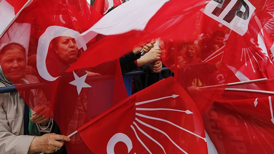 Supporters of main opposition Republican People's Party (CHP) wave Turkish and party flags during an election campaign gathering in Istanbul March 27, 2014. To the adulation of the cheering crowds at his election rallies, Prime Minister Tayyip Erdogan paints a picture of an "evil alliance" plotting to topple him and break Turkey. In another place, on another day, his chief rival portrays him as a rogue doomed to jail or exile. Sunday's local polls have taken on a significance far beyond what anyone could ha