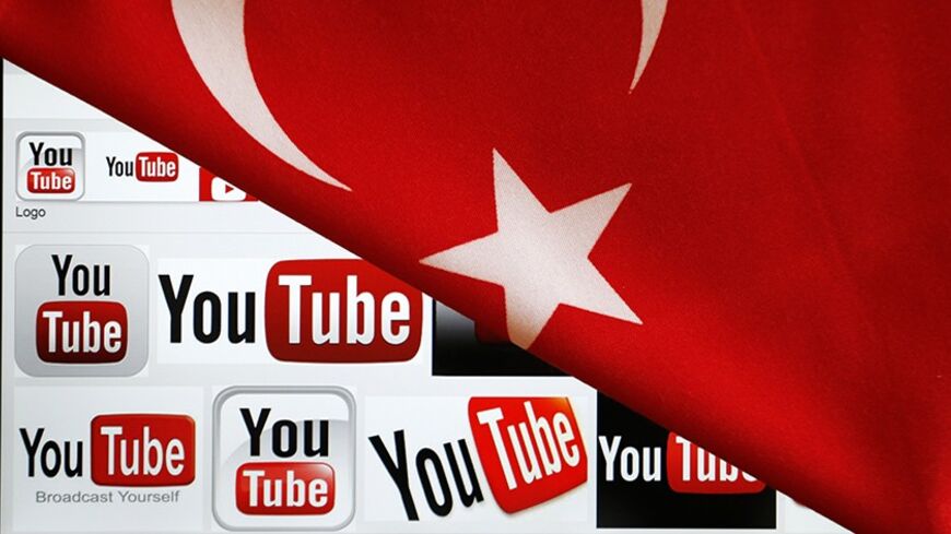 YouTube logos displayed on a laptop screen partially covered with Turkey's national flag in this photo illustration taken in Ankara March 27, 2014.  Turkish Prime Minister Tayyip Erdogan described the leaking on YouTube on Thursday of a recording of top security officials discussing possible military operations in Syria as "villainous" and the government blocked access to the video-sharing site. REUTERS/Umit Bektas (TURKEY - Tags: CIVIL UNREST POLITICS PORTRAIT SCIENCE TECHNOLOGY) - RTR3IVDE