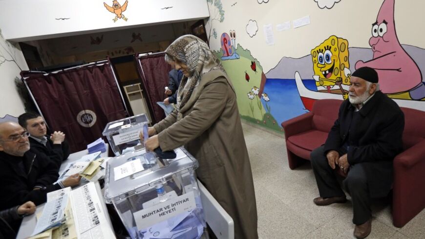 A woman casts her ballot inside a polling station during municipal elections in Istanbul March 30, 2014. REUTERS/Murad Sezer (TURKEY  - Tags: POLITICS ELECTIONS)   - RTR3J5TY