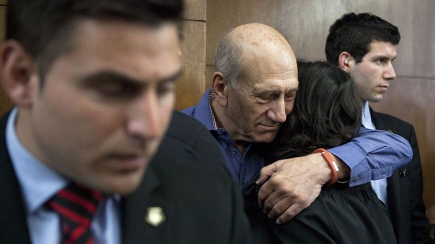Former Israeli Prime Minister Ehud Olmert (2nd L) hugs a woman while waiting to hear his verdict at the Tel Aviv District Court March 31, 2014. The court convicted Olmert of bribery on Monday over his ties to a real-estate deal while in his previous post of Jerusalem mayor, likely ending any prospect of a political comeback. REUTERS/Dan Balilty/Pool (ISRAEL - Tags: POLITICS CRIME LAW PROFILE TPX IMAGES OF THE DAY) - RTR3JAMO