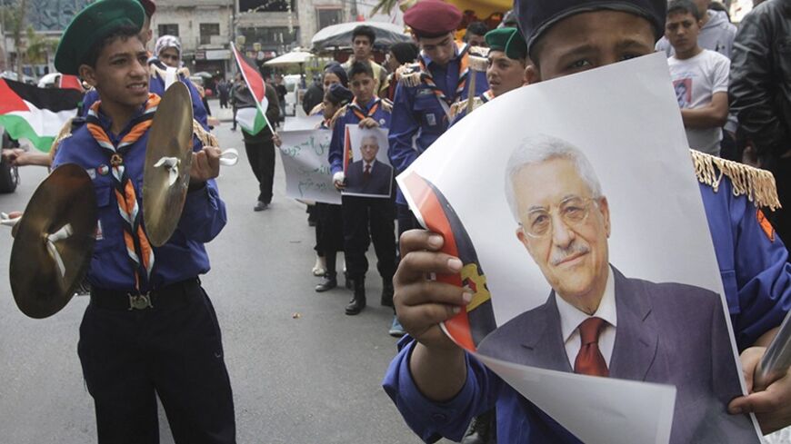 Palestinian scouts hold posters of Palestinian President Mahmoud Abbas during a Fatah rally in support of Abbas in the West Bank city of Nablus April 2, 2014.  A surprise decision by President Mahmoud Abbas to sign more than a dozen international conventions giving Palestinians greater leverage against Israel left the United States struggling on Wednesday to put peace talks back on track. REUTERS/Abed Omar Qusini (WEST BANK - Tags: POLITICS) - RTR3JMDL