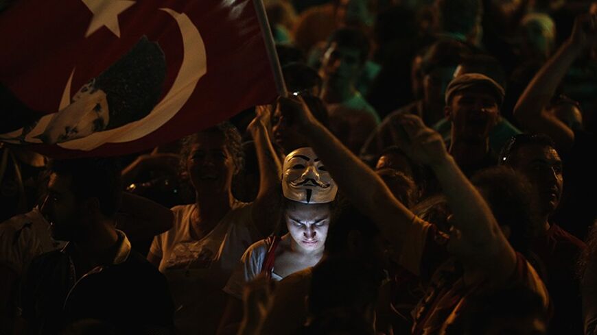 A protester uses her mobile phone during a demonstration at Taksim Square in Istanbul June 8, 2013. Turkish Prime Minister Tayyip Erdogan's AK Party on Saturday ruled out early elections as thousands of anti-government demonstrators defied his call for an immediate end to protests. REUTERS/Stoyan Nenov (TURKEY - Tags: POLITICS CIVIL UNREST TPX IMAGES OF THE DAY) - RTX10GYJ