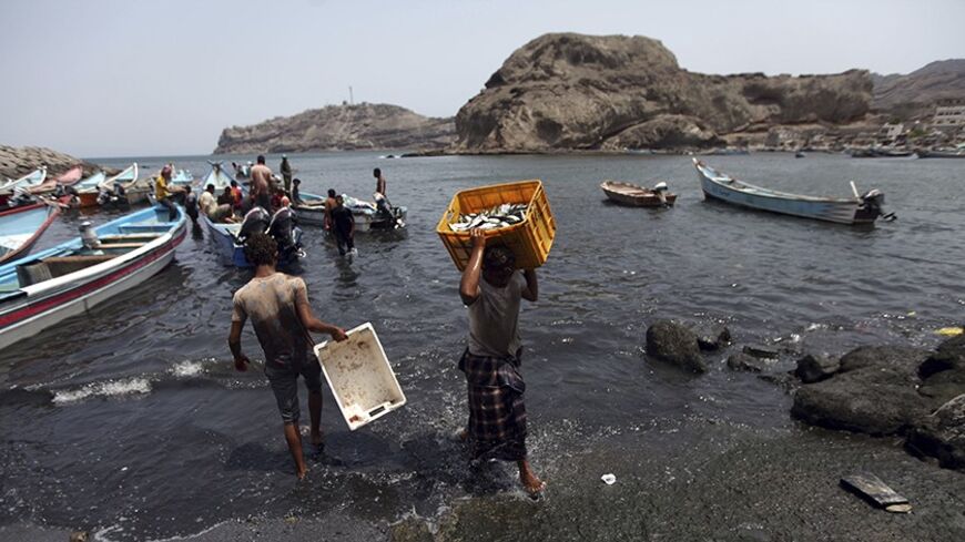 Fishermen transport fish from their boats at a harbour in the southern city of Aden, situated at the mouth of the Red Sea, August 22, 2013. REUTERS/Mohamed al-Sayaghi (YEMEN - Tags: SOCIETY) - RTX12TL4