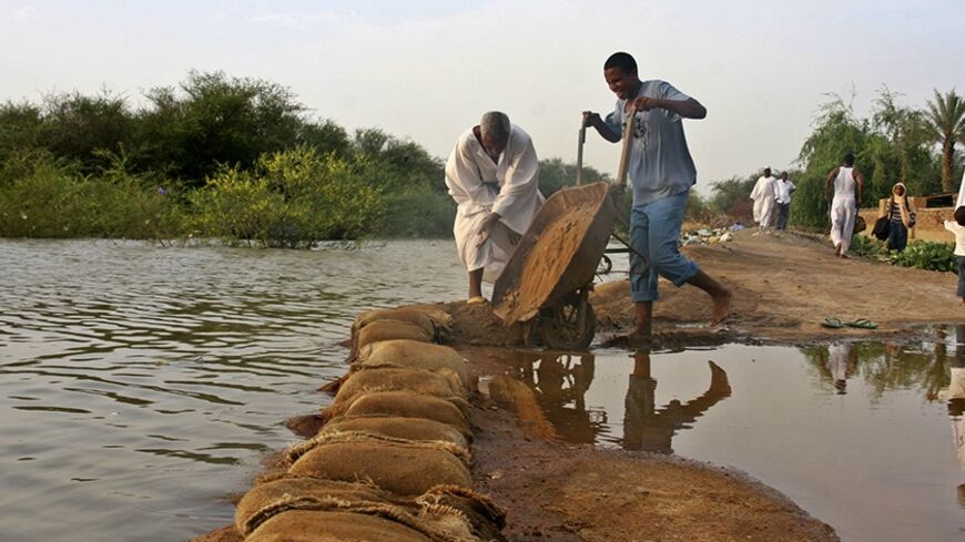 Men work to build a flood barrier to protect their houses from the rising water of the White Nile River in South Khartoum August 26, 2013. Heavy rains and flood in the country have affected the lives and properties of some 320,000 people, according to a report by the World Health Organization (WHO) last week.  REUTERS/Stringer (SUDAN - Tags: ENVIRONMENT DISASTER) - RTX12XDP