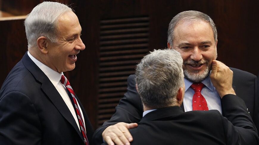 Israel's Prime Minister Benjamin Netanyahu (L) and Finance Minister Yair Lapid (back to camera) congratulate Israeli far-right leader Avigdor Lieberman after he was sworn in as Israel's Foreign Minister at the parliament in Jerusalem November 11, 2013. Lieberman was sworn in as foreign minister on Monday after his acquittal on corruption charges, a development that could further complicate peace talks with the Palestinians. REUTERS/Amir Cohen (JERUSALEM - Tags: POLITICS TPX IMAGES OF THE DAY) - RTX159MP