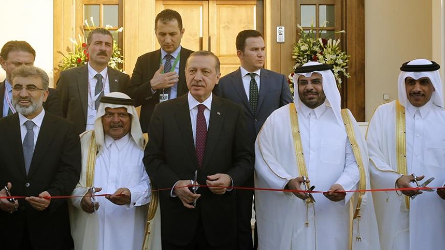 Turkey's Prime Minister Tayyip Erdogan (C) cuts the ribbon during the opening ceremony of the new building of the Turkish Embassy in Doha December 4, 2013.  REUTERS/Mohammed Dabbous (QATAR - Tags: POLITICS) - RTX163G5