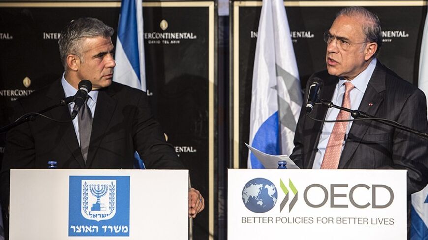 Secretary-General of the Organisation for Economic Co-operation and Development (OECD) Jose Angel Gurria (R) speaks during a news conference with Israel's Finance Minister Yair Lapid in Tel Aviv December 8, 2013. Gurria was in Israel on Sunday to present the organisation's 2013 report on Israel's economy. The Bank of Israel should prepare for interest rate increases once the global economy returns to normal, the OECD said. REUTERS/ Nir Elias (ISRAEL - Tags: POLITICS BUSINESS) - RTX169RU