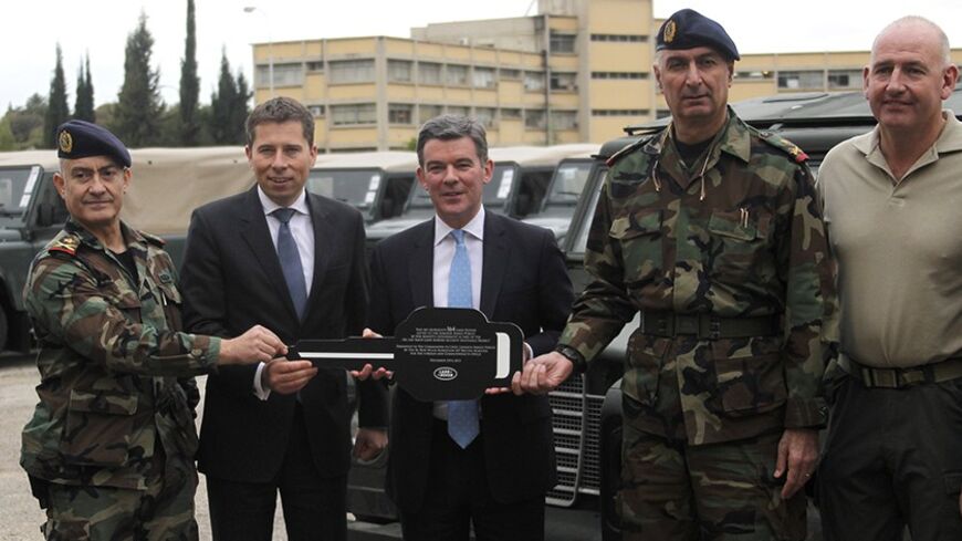 Members of the Lebanese army stand with the British ambassador to Lebanon, Tom Fletcher, and Hugh Robertson, British Secretary of State for the Middle East and North Africa, as they give the aid to the Lebanese army in Kfarshima, east of Beirut December 10, 2013. REUTERS/Sharif Karim (LEBANON - Tags: POLITICS) - RTX16CAH