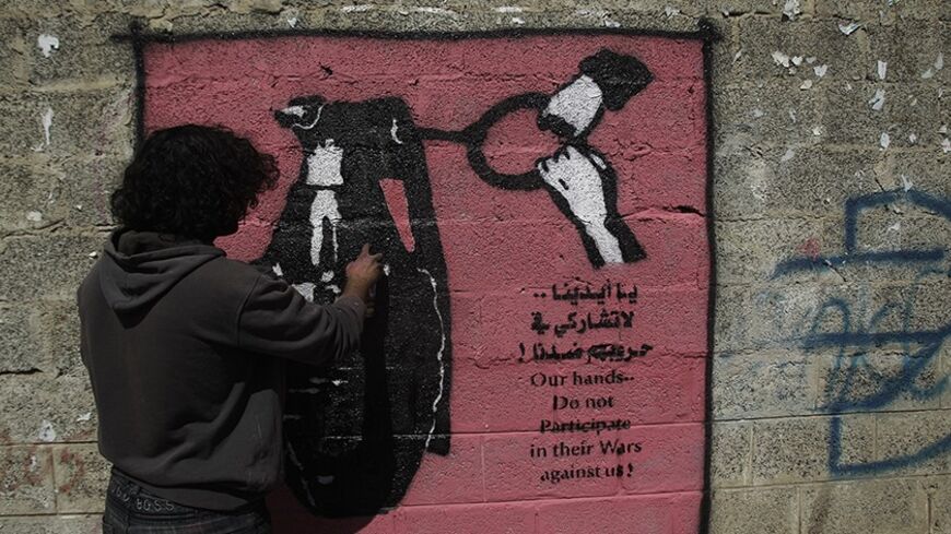 Artist Murad Subai paints a graffiti depicting a grenade on a street in Sanaa January 9, 2014. The paint is part of a graffiti campaign against armed conflicts in Yemen. REUTERS/Khaled Abdullah (YEMEN - Tags: POLITICS SOCIETY CIVIL UNREST) - RTX177LB