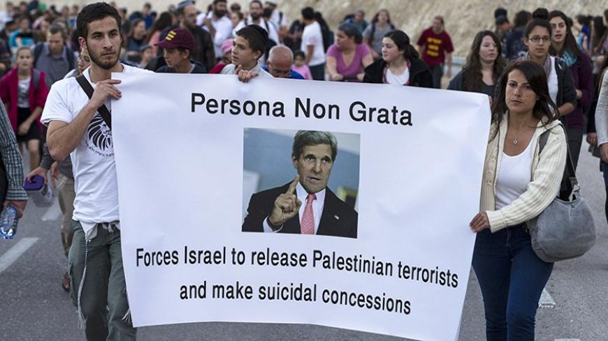 Right-wing Israelis hold a banner depicting U.S Secretary of State John Kerry as they march during a rally in E1, an area in the West Bank near Jerusalem February 13, 2014. Thousands of right-wing Israelis took part in the rally on Thursday in E1, a geographically sensitive area which connects the two parts of the Israeli-occupied West Bank outside Arab suburbs of East Jerusalem, calling for Israeli building in the area which Palestinians seek for a contiguous future state. REUTERS/Baz Ratner (WEST BANK - T