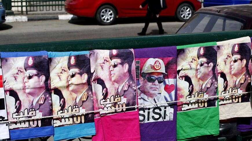 T-shirts with pictures of Field Marshal Abdel Fattah al-Sisi are displayed for sale by a street vendor in Tahrir square in Cairo February 22, 2014.REUTERS/Asmaa Waguih (EGYPT - Tags: POLITICS MILITARY TRAVEL) - RTX19ACF