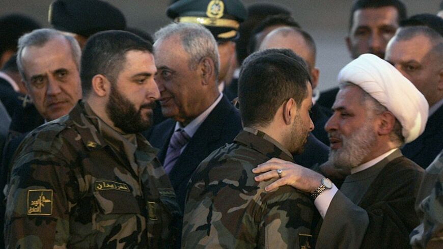 Lebanon's President Michel Suleiman (L) and Parliament speaker Nabih Berri (3rd L) look on as Hezbollah's deputy leader Sheikh Naim Kassem (C) greets released Lebanese prisoner Maher Qorani at Beirut airport July 16, 2008. Five Lebanese freed from captivity in Israel were flown to a heroes' welcome in Beirut on Wednesday after Hezbollah returned the bodies of two Israeli soldiers seized in a cross-border raid in 2006. REUTERS/ Mohamed Azakir   (LEBANON) - RTX7ZV4