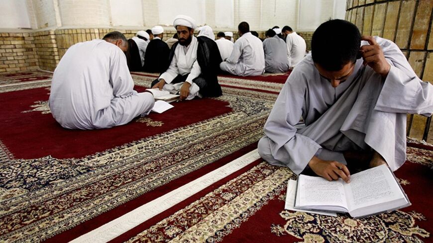NAJAF, IRAQ:  An Iraqi Shiite scholar (2nd L) lectures a student while another one (R) reviews his lesson at a religious school for clerics, known in Arabic as Haouza, in the holy city of Najaf, 160 kms (100 miles) south of Baghdad, 05 August 2006. The teaching method at the clerical school in Najaf has not radically changed since its establishment in 1056 AD, with the exception of adding natural sciences subjects to the curriculum.  AFP PHOTO/ALI AL-SAADI  (Photo credit should read ALI AL-SAADI/AFP/Getty I