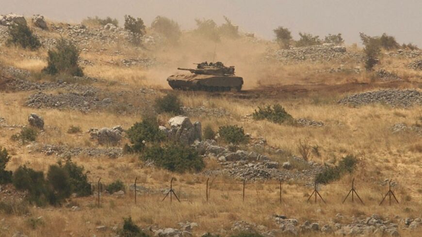 An Israeli tank patrols the Shebaa Farms area, wedged between Lebanon and the Israeli-occupied Golan Heights July 8, 2009. A Lebanese army colonel suspected of collaborating with Israel fled to the Jewish state last week, a Lebanese security source said on Tuesday. REUTERS/Ali Hashisho (LEBANON POLITICS MILITARY) - RTR25GD9
