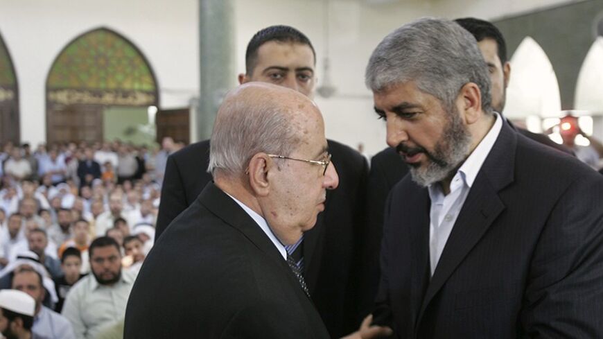 Hamas leader Khaled Meshaal (R) shakes hands with senior Fatah leader Saleem Zanoun during the funeral of Meshaal's father in Amman August 29, 2009. Meshaal was allowed back into Jordan for first time since 1999 for the funeral. REUTERS/Muhammad Hamed (JORDAN POLITICS) - RTR277RI