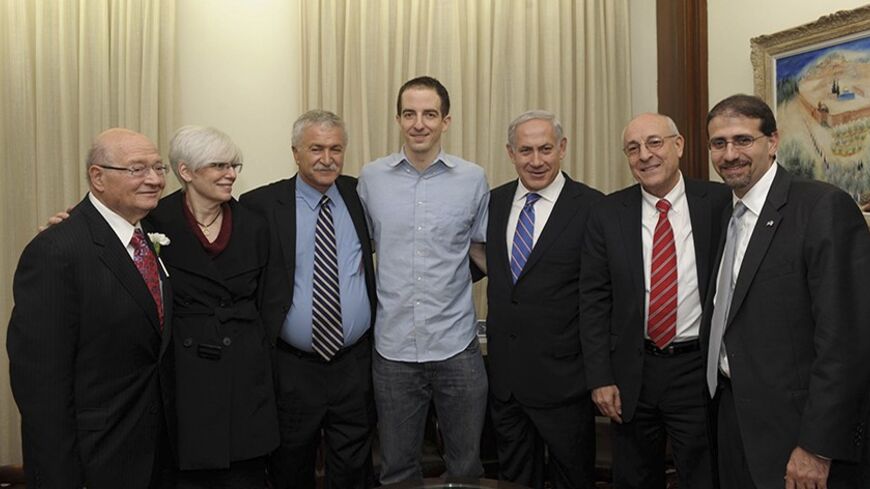 American-Israeli Ilan Grapel (C) poses for a photograph with Israel's Prime Minister Benjamin Netanyahu (3rd R), Israeli negotiator Yitzhak Molcho (2nd R), U.S ambassador to Israel Daniel Shapiro (R), Israeli Knesset member Yisrael Hasson (3rd L), U.S. Congressman Gary Ackerman (L) and Grapel's mother (2nd L) in Jerusalem in this handout picture released October 27, 2011 by the Israeli Government Press Office (GPO). Egypt released the American-Israeli it held as an alleged spy and Israel freed 25 Egyptians 
