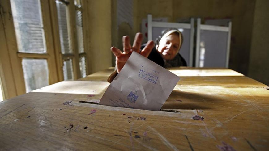 A woman casts her vote during the second round of parliamentary run-off elections at Shubra in El-Kalubia, on the outskirts of Cairo January 10, 2012. Islamists aimed to cement control over Egypt's lower house of parliament as a final phase of voting began on Tuesday, while a secular party's plan to boycott elections for the upper chamber threatened to weaken the liberal bloc. REUTERS/Mohamed Abd El-Ghany  (EGYPT - Tags: POLITICS ELECTIONS TPX IMAGES OF THE DAY) - RTR2W3HV