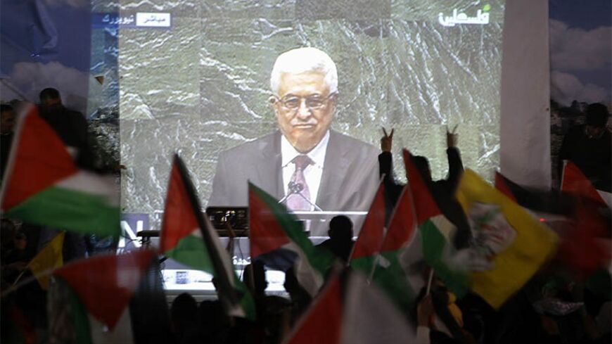 Palestinians take part in a rally while the speech of Palestinian President Mahmoud Abbas is being projected in the West Bank city of Ramallah November 29, 2012. The 193-nation U.N. General Assembly overwhelmingly approved a resolution on Thursday to upgrade the Palestinian Authority's observer status at the United Nations from "entity" to "non-member state," implicitly recognizing a Palestinian state.   REUTERS/Mohamad Torokman (WEST BANK - Tags: POLITICS) - RTR3B1GJ