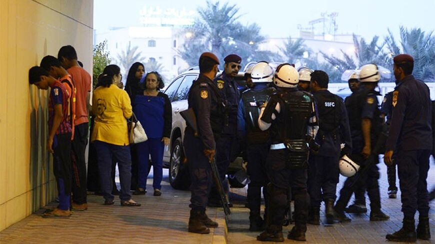 Riot police briefly detain protesters during clashes after an anti-government rally organised by Bahrain's main opposition party Al Wefaq in Budaiya March 21, 2014. REUTERS/Stringer (BAHRAIN - Tags: POLITICS CIVIL UNREST) - RTR3I3JW